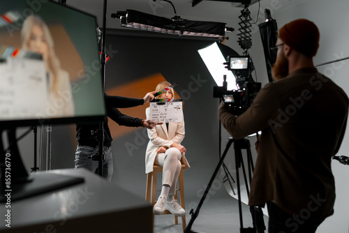 Woman gestures with clapper board in front of man, creating fun event display