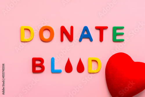 Colored letters with the text Donate blood, drops of blood and a red heart. Blood donation concept
