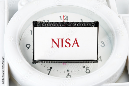 The word Nippon Individual Savings Account. NISA on a business card on a stand on a lying watch photo