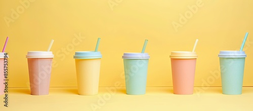 Different disposable cups on yellowpastel background. with copy space image. Place for adding text or design