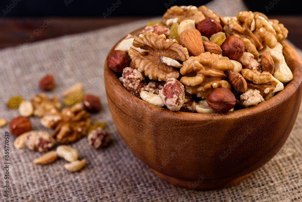 Mixed nuts in wooden bowl on wooden background. Mixed nuts in wooden bowl on wooden background.