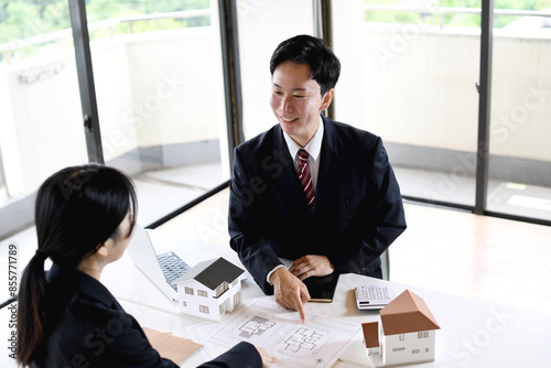 建築模型の前で会話する男女のビジネスマン