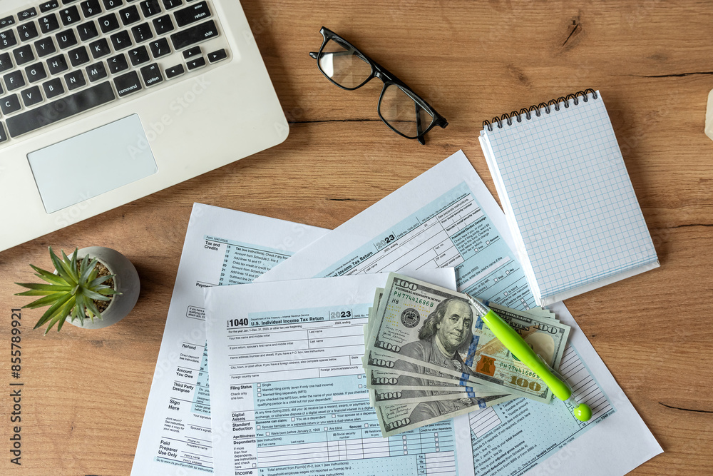 Obraz premium US 1040 tax form with dollar pen and laptop, april tax season