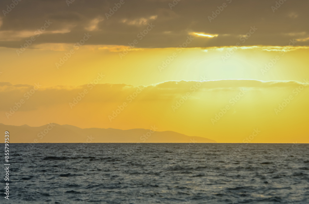 Waves coming into the shore and view of the coastline at sunset Waves coming into the shore and view of the coastline at sunset