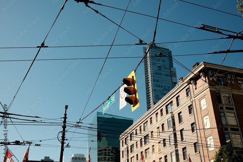 Naklejka premium Urban scene of Robson Street in downtown Vancouver with traffic lights and overhead wires