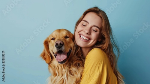 Young smiling happy cheerful owner woman with her best friend retriever wear casual clothes cuddle hug dog close eyes isolated on plain pastel light blue background studio. Take care about pet concept © Nataliya