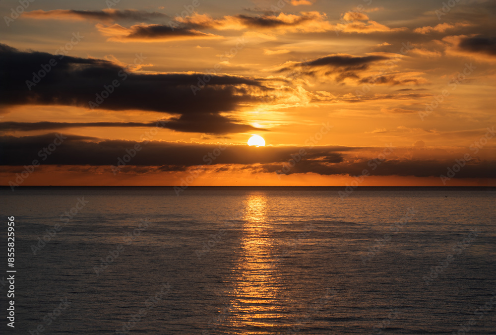 Sunset over the water with birds flying against sunlight on the Mediterranean Sea Sunset over the water with birds flying against sunlight on the Mediterranean Sea