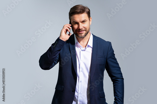 Portrait of a business man in suit using mobile phone. Caucasian man using smart phone cellphone for calls, social media, mobile app. Online chatting. Guy talking on the phone.