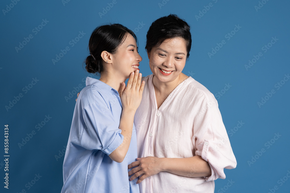 Image of an Asian mother and child posing on a blue background. Image of an Asian mother and child posing on a blue background.