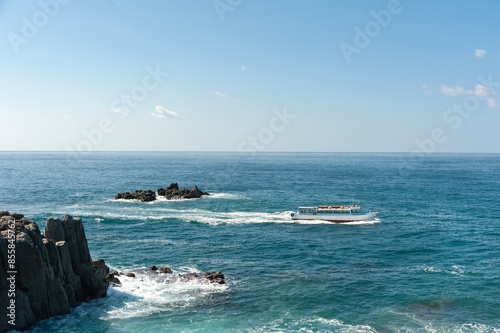A tour boat sailing in the Sea of Japan near Tojinbo in Fukui Prefecture photo