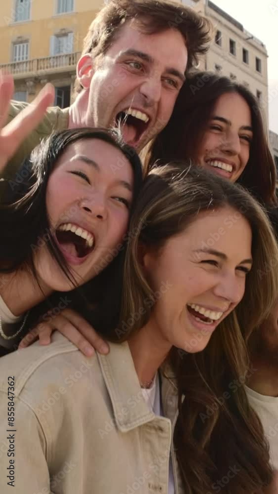 Vertical video. Diverse group of young adult friends having fun hugging each other outside. Joyful millennial people laughing enjoying time together. Community and friendship concept Vertical video. Diverse group of young adult friends having fun hugging each other outside. Joyful millennial people laughing enjoying time together. Community and friendship concept