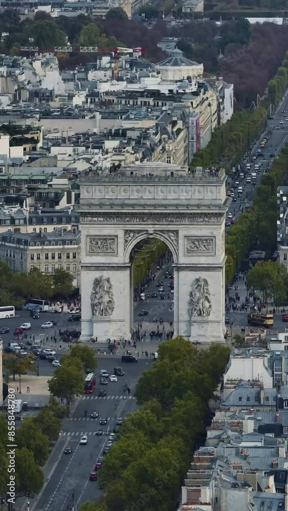 Arc de Triomphe and car traffic on roundabout, Paris cityscape, France. Aerial orbiting. Triumphal arch with Tour Eiffel in background, Paris cityscape, France. Aerial drone panoramic view