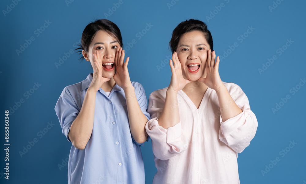 Image of an Asian mother and child posing on a blue background. Image of an Asian mother and child posing on a blue background.