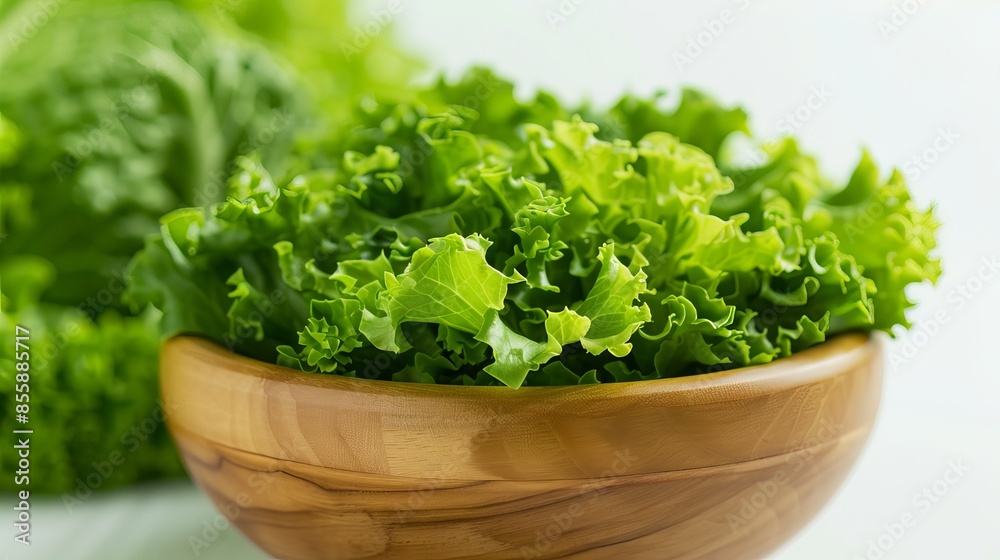 Fresh green lettuce in a wooden bowl on a light background. Healthy organic salad ingredient, perfect for a nutritious meal. Fresh green lettuce in a wooden bowl on a light background. Healthy organic salad ingredient, perfect for a nutritious meal.