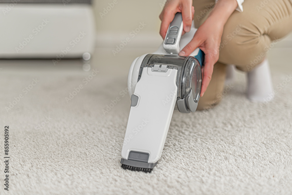 Cleaning carpets and furniture with a cordless handheld vacuum cleaner.