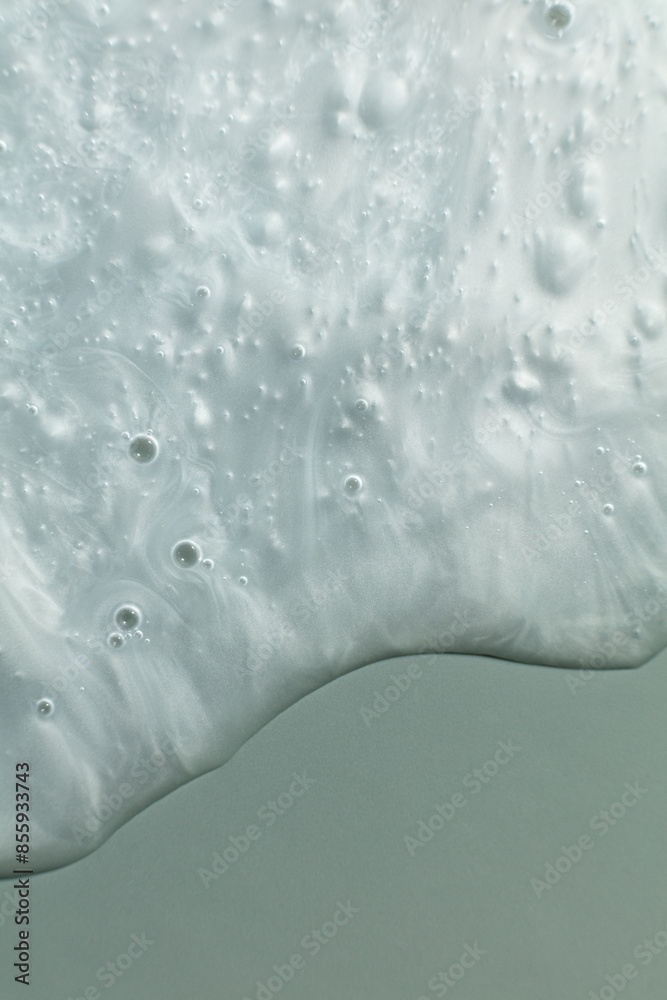 Fototapeta premium Macro shot of a moisturizer's texture showcasing its smooth, glossy surface with visible swirls and bubbles. This detailed close-up highlights the product's creamy and hydrating properties