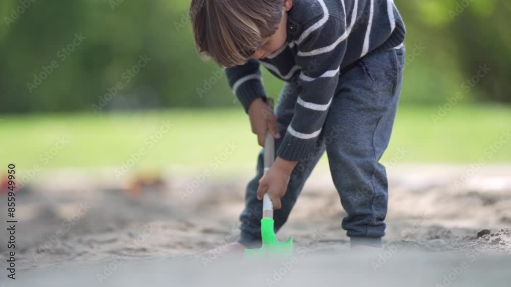 On A Fun Day Outdoors In A Wooded Park, Little Boy In Striped Sweater Plays With His Little Shovel, Digging The Sandbox On A Fun Day Outdoors In A Wooded Park, Little Boy In Striped Sweater Plays With His Little Shovel, Digging The Sandbox