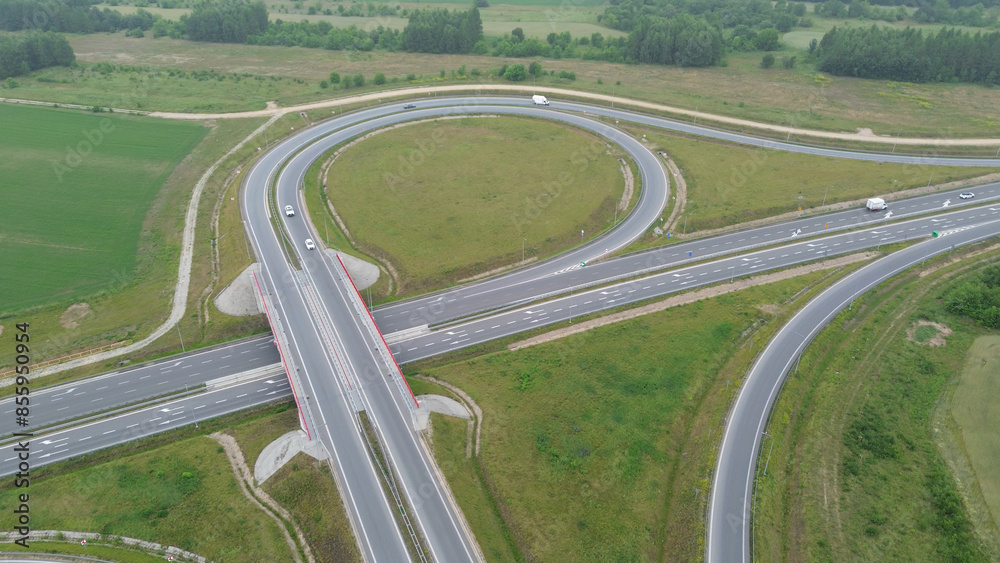 Elevated view of rural highway junction with cars and green landscape Elevated view of rural highway junction with cars and green landscape