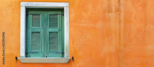 Green window with white frame on orange wall in vintage style. Copy space image. Place for adding text and design