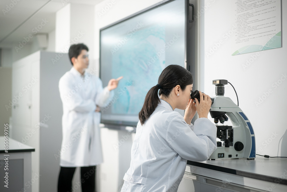 Naklejka premium doctor using microscope in lab