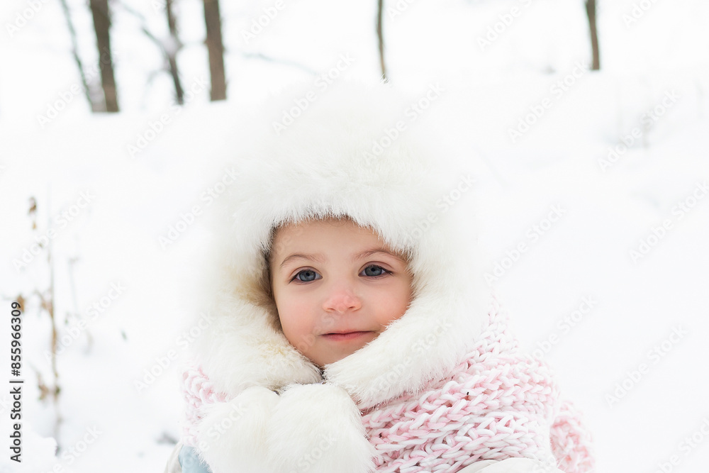 A cute baby in a snowy winter forest. Little girl having fun on winter day. Happy child in winter park A cute baby in a snowy winter forest. Little girl having fun on winter day. Happy child in winter park