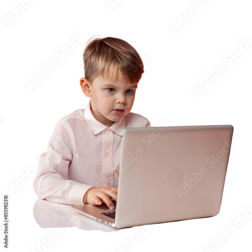 A young boy is sitting at a table with a laptop in front of him