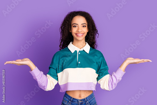 Portrait of lovely young girl arms hold empty space wear shirt isolated on purple color background