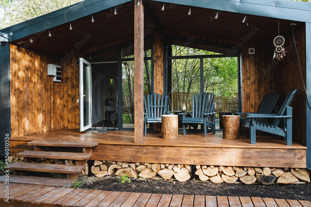Immerse yourself in the serene beauty of a charming wooden cabin retreat, offering a cozy porch with comfortable chairs and stunning nature views. Ideal for a peaceful getaway in the countryside Immerse yourself in the serene beauty of a charming wooden cabin retreat, offering a cozy porch with comfortable chairs and stunning nature views. Ideal for a peaceful getaway in the countryside