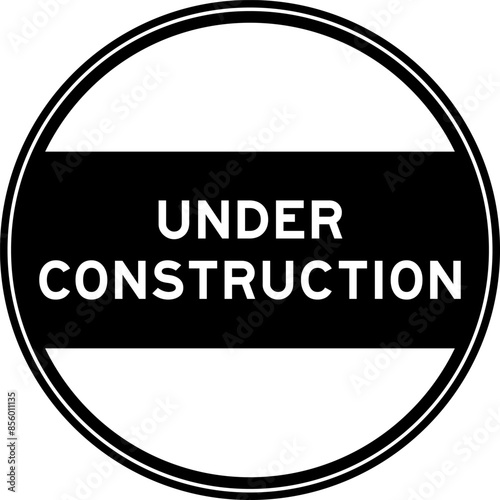 Black color round seal sticker in word under construction on white background