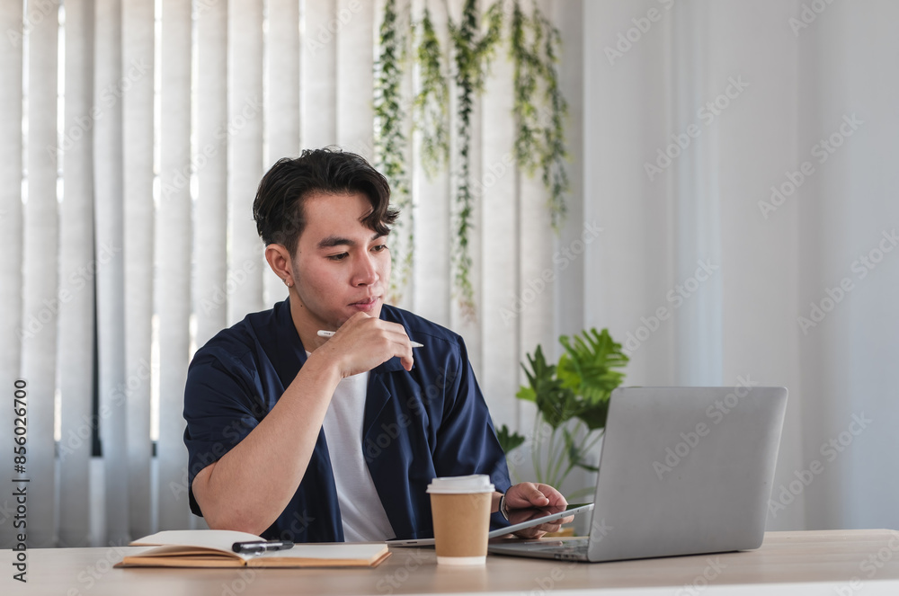 Modern Male Businessman Working Online at Home Office with Laptop and Coffee, Focused and Thoughtful Modern Male Businessman Working Online at Home Office with Laptop and Coffee, Focused and Thoughtful