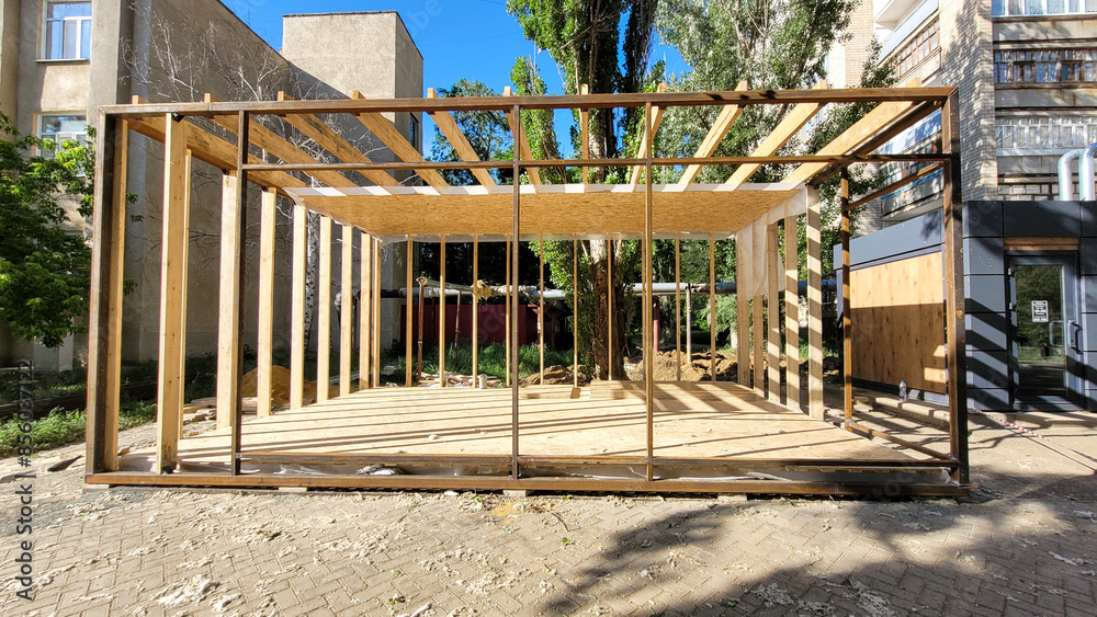 Construction a street shopping pavilion for a store, all stages of construction, detailed overview. The third stage - installation of wooden boards around the perimeter and on the roof