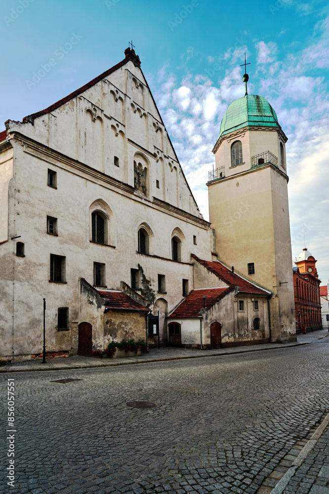 Fototapeta premium Brick tower of a historical church in the city of Wschowa in the evening