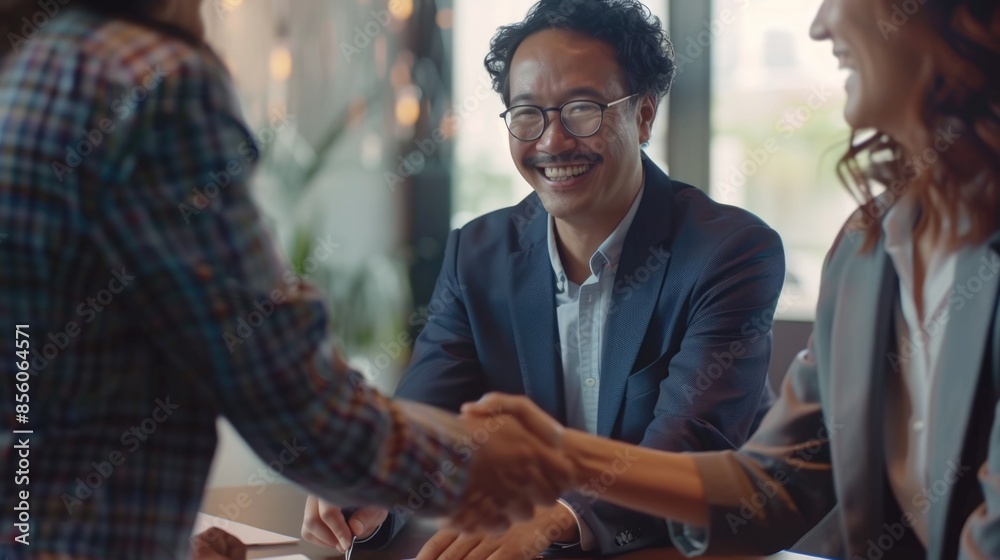 Business Handshake at a Meeting with Smiling Colleagues Business Handshake at a Meeting with Smiling Colleagues