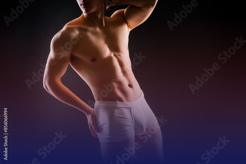 Fototapeta Man holds barbell weights, young adult strong male in white briefs, studio shot