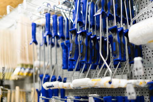 A store display of paint brushes and rollers. The display is organized by color and size.