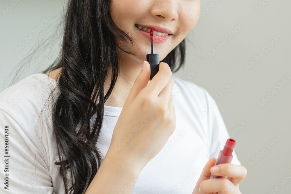 Daily makeup routine, Asian young women looks in the mirror during applying lipstick on her lip. Daily makeup routine, Asian young women looks in the mirror during applying lipstick on her lip.