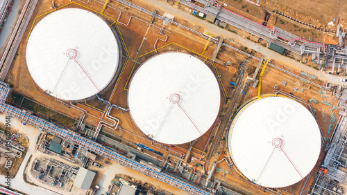 Aerial view oil storage tank, White oil tank storage chemical petroleum petrochemical refinery product at oil terminal, Business commercial trade fuel energy transport by tanker ship vessel.