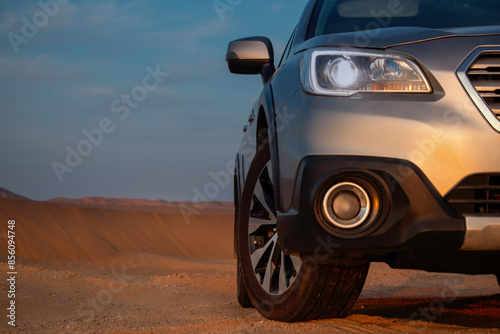 Close-up of a car  in the sand of the Namib Desert on a sunny day. 
