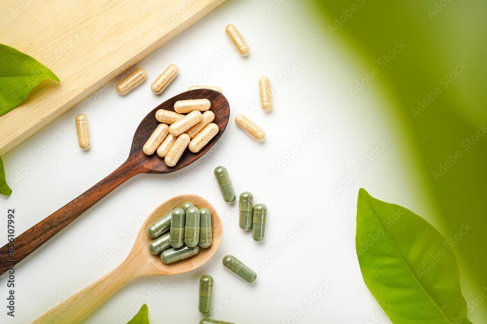 Herbal capsules in wooden spoon, Natural herbs, Alternative Medicine, Herbal supplement Herbal capsules in wooden spoon, Natural herbs, Alternative Medicine, Herbal supplement