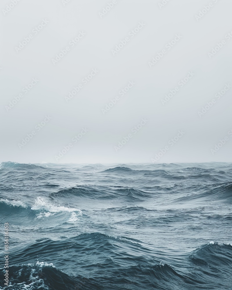 Expansive ocean view with subtle wave patterns under a misty sky, evoking depth and reflection
