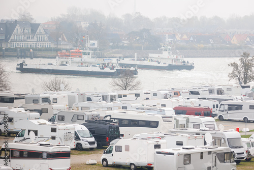 RV camper van parking place at Warnemünde Rostock harbor canal cruise liner pier ferry vessel ship background. Many recreational vehicle parked Germany port harbor foggy day. Travel tourism adventure