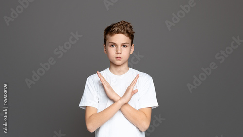 Cuadro en lienzo Teenager with arms crossed in an X shape, showcasing refusal or denial, isolated
