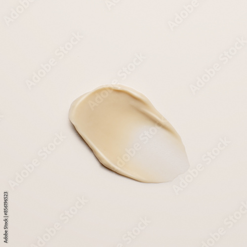 Single vibrant yellow swatch of creamy cosmetic product applied as smear against white background, ideal for color comparison and texture analysis