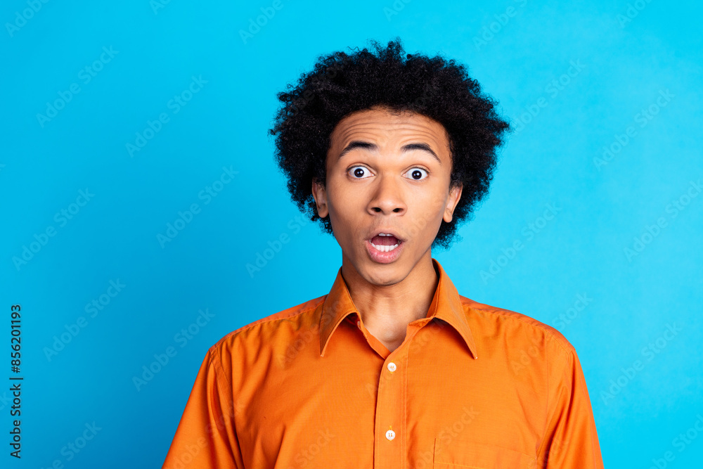 Photo of funky impressed guy dressed orange shirt open mouth emtpy space isolated blue color background Photo of funky impressed guy dressed orange shirt open mouth emtpy space isolated blue color background