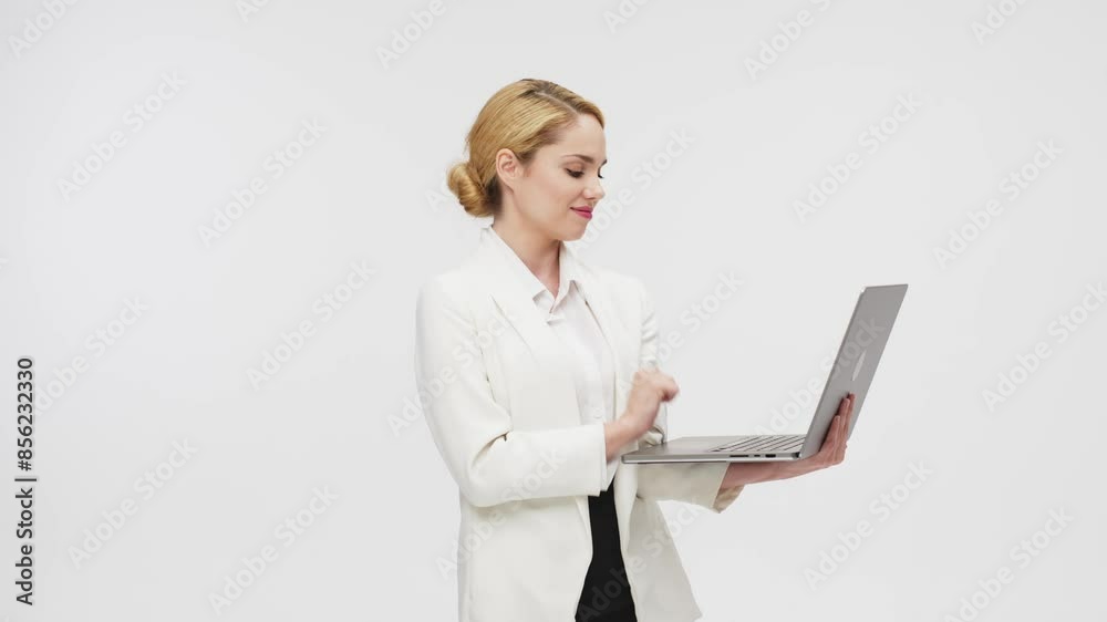 Confident blonde woman dressed in stylish business clothes against a white studio background. Business lady uses a laptop. Online work or study concept. Confident blonde woman dressed in stylish business clothes against a white studio background. Business lady uses a laptop. Online work or study concept.