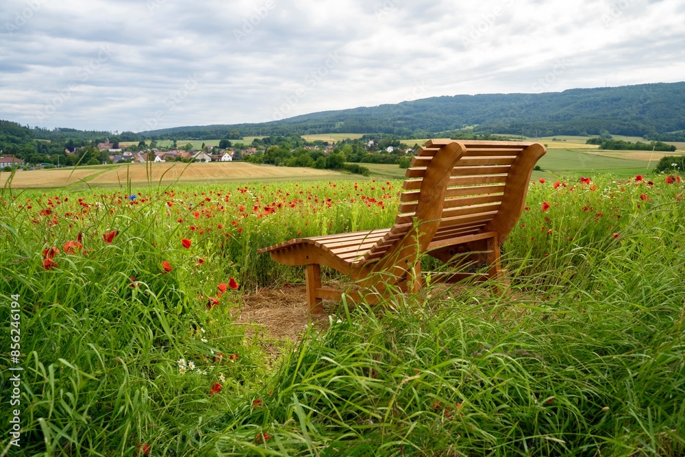 Mohnblüte im GEO Naturpark Frau-Holle-Land (Hessen, Deutschland). Eine Bank im Mohnfeld. Mohnblüte im GEO Naturpark Frau-Holle-Land (Hessen, Deutschland). Eine Bank im Mohnfeld.