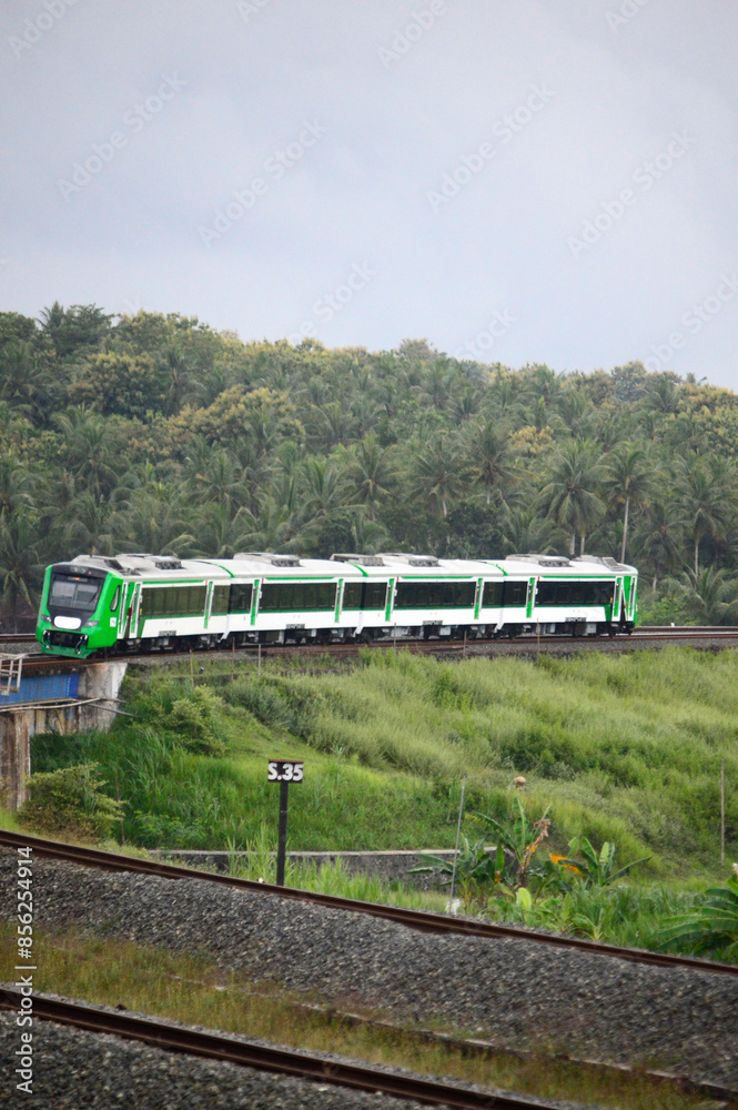 View of a passenger train moving in a rural or hilly area View of a passenger train moving in a rural or hilly area