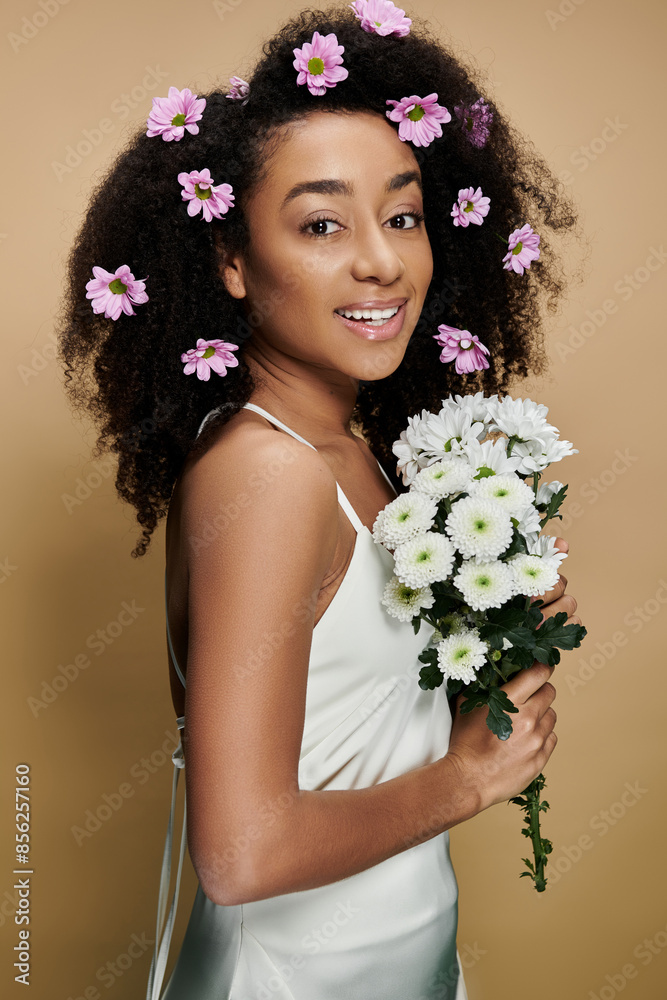 A beautiful African American woman with natural makeup and flowers in her hair smiles while holding a bouquet of white flowers. A beautiful African American woman with natural makeup and flowers in her hair smiles while holding a bouquet of white flowers.