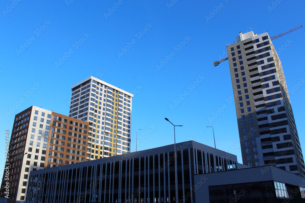 Obraz premium construction with cranes, construction of the new multi - storey residential building under construction. construction of new residential building
