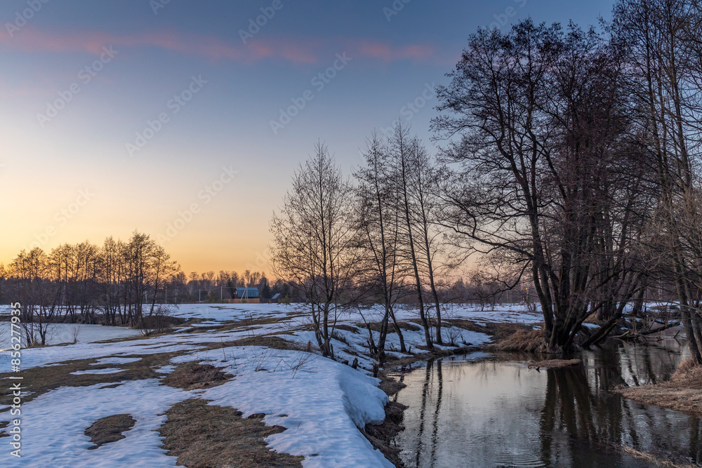 A snowy field with a river running through it A snowy field with a river running through it